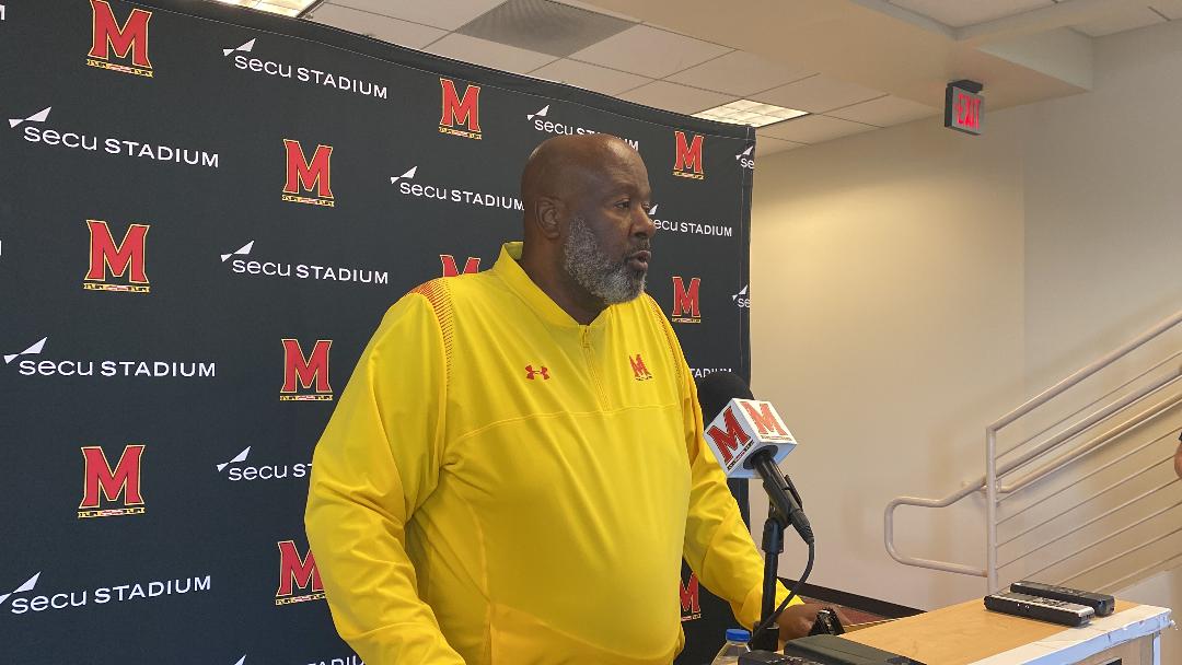 Terps head coach Mike Locksley stands at podium addressing the media for the Michigan matchup Saturday