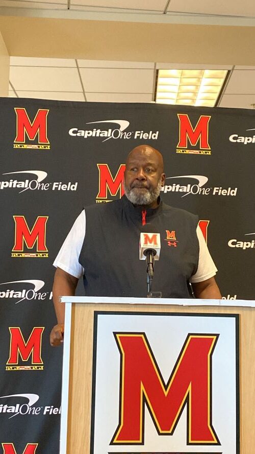 Maryland football head coach stands at podium for Tuesday press conference