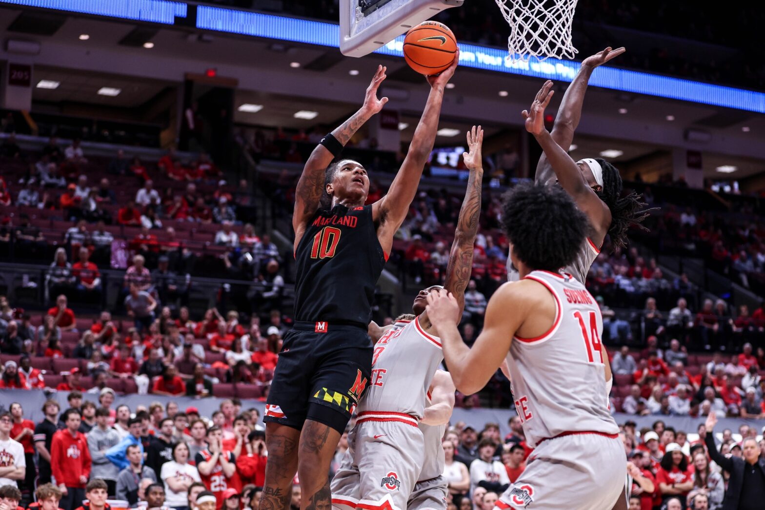 Maryland basketball forward Julian Reese attempts a layup against three Ohio State Buckeye defenders